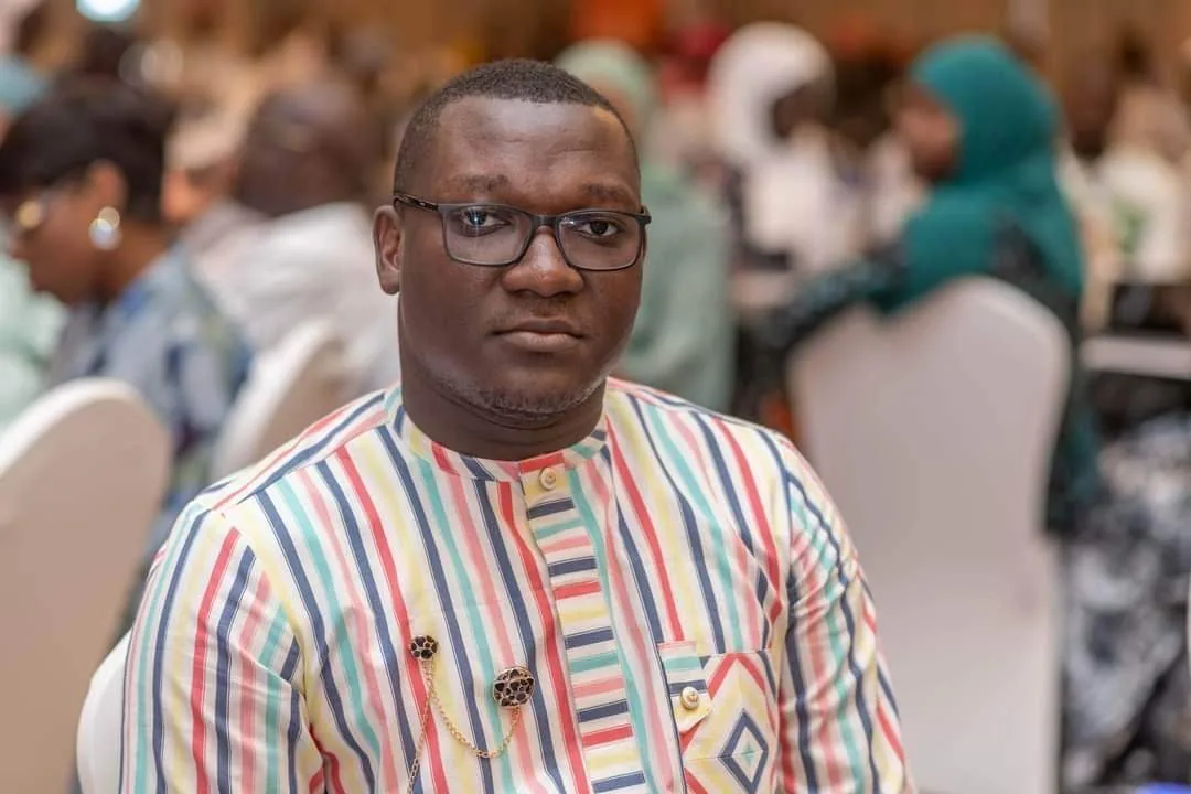 A seated attendee in patterned clothing