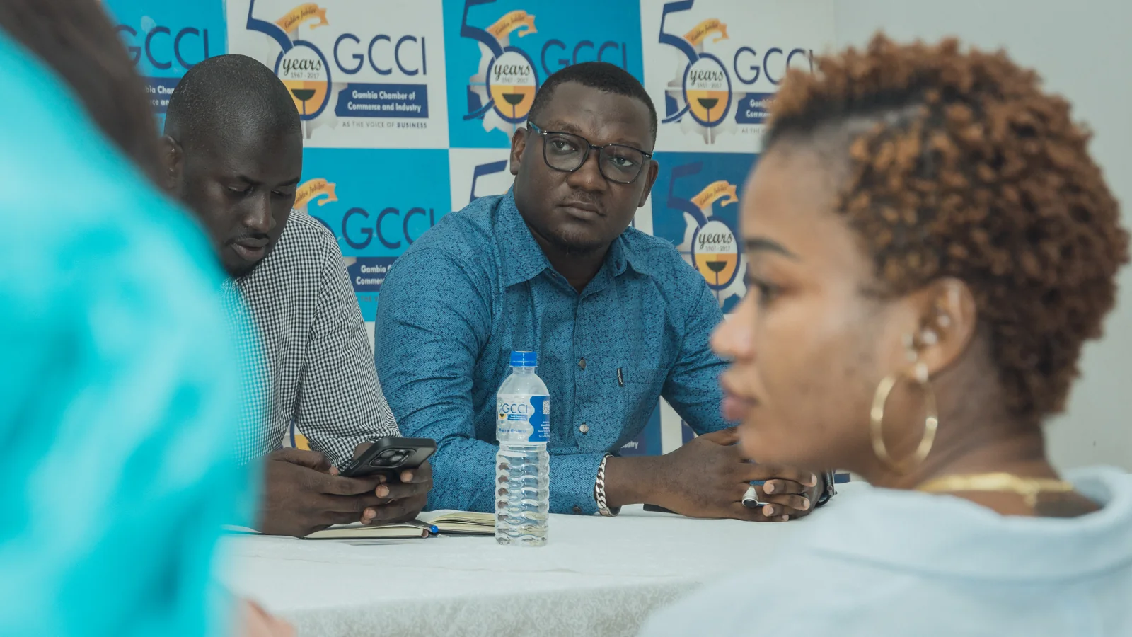 A participant speaking across the meeting table
